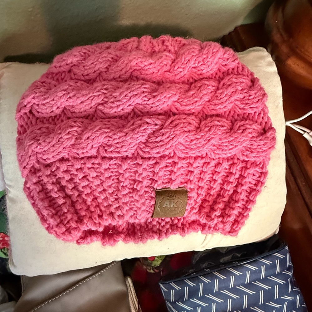 Alaska Chicks Co. messy bun hat in pink with a leather patch accent.